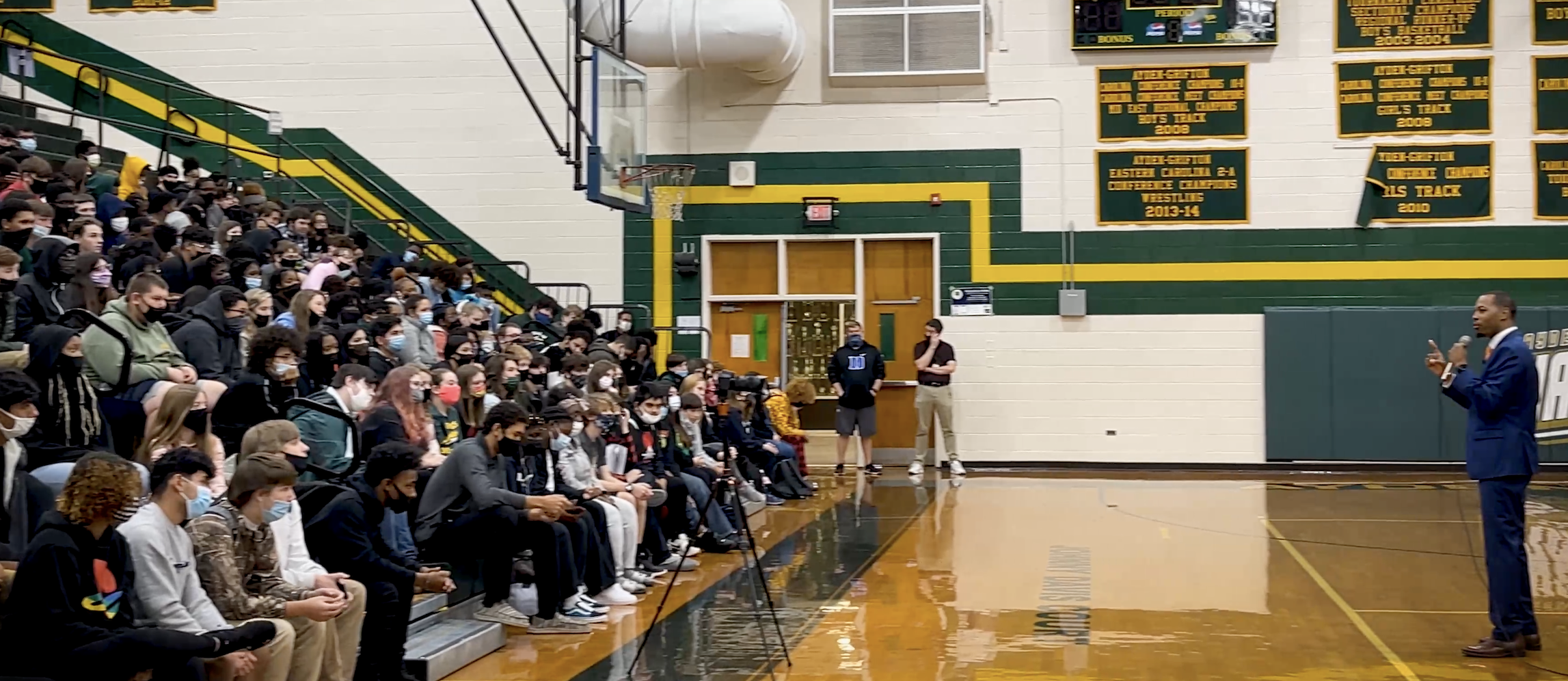 Joshua Burney hosting a full high school gymnasium assembly
